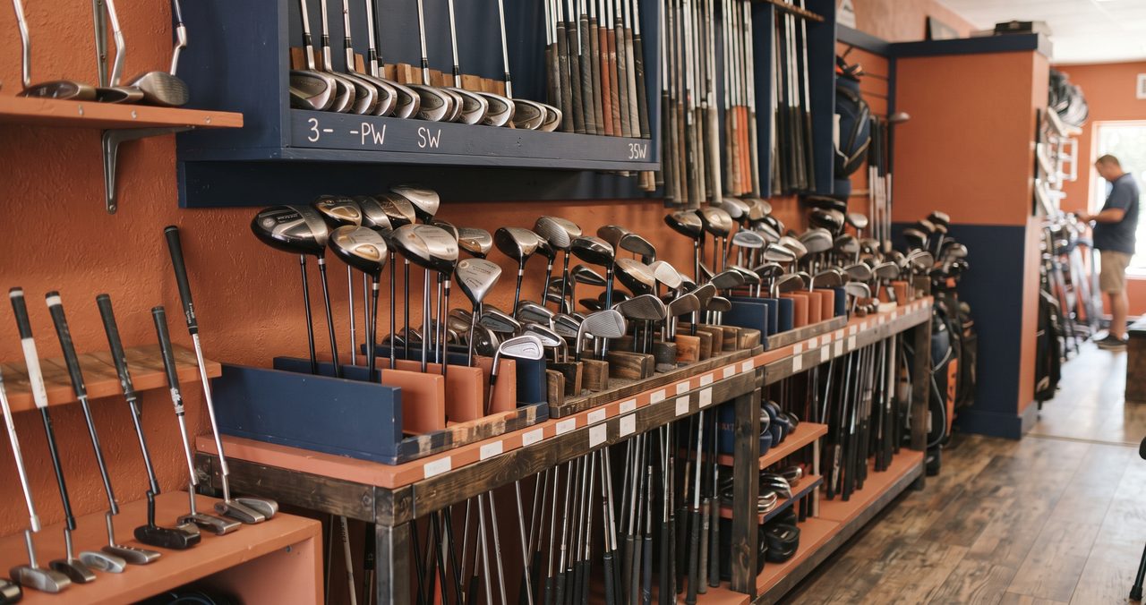 中古ゴルフクラブが並ぶスポーツ用品店の陳列棚の写真